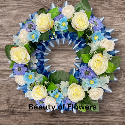 Artificial Blue and White Wreath - This stunning and beautiful artificial blue and white wreath comes in a size of approx. 18" diameter. Lovingly prepared personally by our talented florist in our Derby city store. This design can be made in other colour choices. We can also personalise this design with a ribbon sash with a name or short message. Please contact us to discuss your requirements