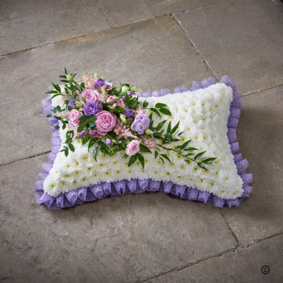 Lilac Pillow - This pillow tribute conveys comfort and rest for a loved one. With a lilac ribbon edge, white base and lilac spray, but can be made in other colours.